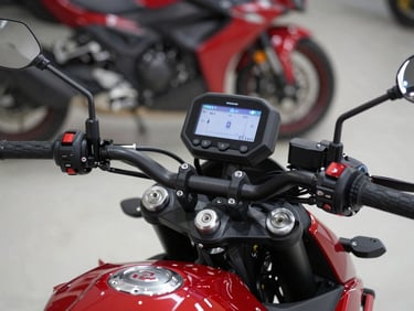 Close-up shot of a Honda motorcycle handlebar with digital display illuminated, pristine showroom setting, modern tech vibe