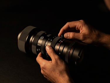 Hands adjusting luxury studio gear, high-contrast chiaroscuro, golden highlights