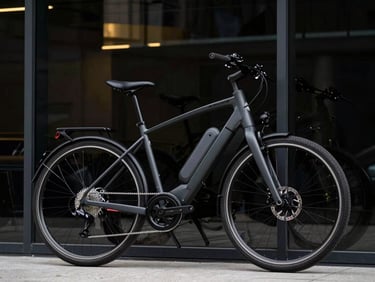 Premium electric bicycle leaning against a modern glass facade, sharp details of the integrated frame battery, high-contrast reflections, 35mm lens