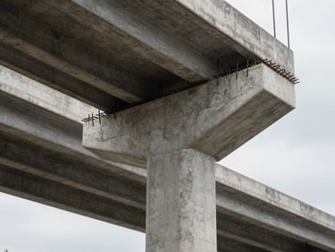 Close-up of a completed concrete highway overpass support column with rebar detail, overcast natural light, engineering documentation context, no people