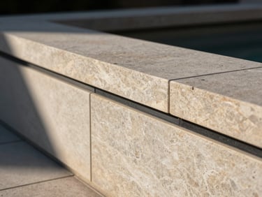 Close-up architectural shot of flawless natural stone coursing on a modern patio wall, crisp late-afternoon sunlight casting sharp shadows, deep charcoal joints