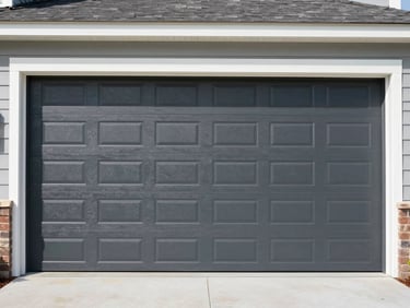 Wide shot of a newly installed modern dark gray garage door on a residential home in Anderson, SC, clean lines, bright natural daylight, crisp industrial photography, 35mm