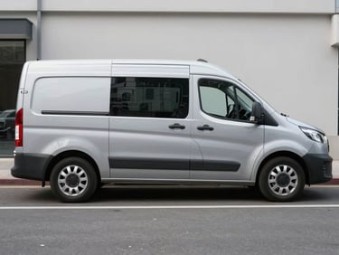 A modern silver service van parked on a clean city street, neutral daylight, sharp focus