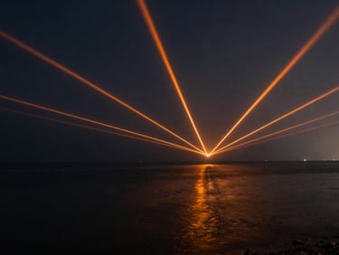 Long-exposure shot of sharp orange and white laser vectors projected across a dark coastal bay in Al-Khobar, reflecting on water, 35mm lens