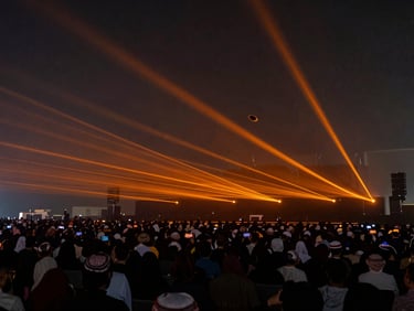 Long-exposure shot of a solid orange laser canopy floating over a massive indoor corporate event in Riyadh, dark atmosphere, 35mm lens