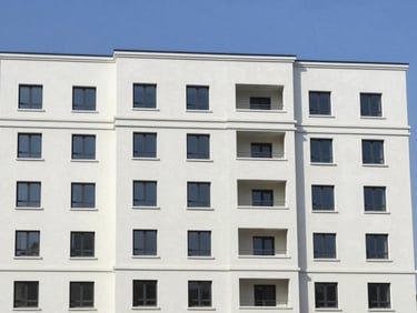 Wide shot of a freshly painted multi-story residential building facade, clean lines, bright natural daylight, professional architectural photography, sharp focus