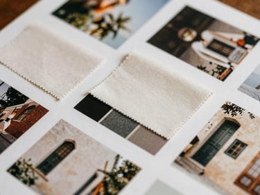 Overhead view of an art director's mood board, featuring fabric swatches, architectural photos, and elegant color palettes.