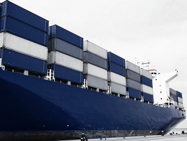 High-contrast duotone photography of a massive container ship docked at Port Klang, stark deep navy blue and crisp white tones, sharp architectural angles, 35mm perspective.