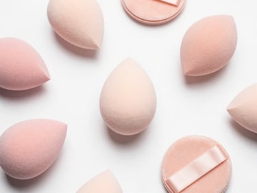 Minimalist flat-lay of latex-free beauty blenders and velvet powder puffs in soft pastel tones, clean studio lighting.