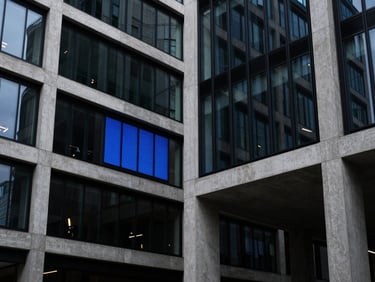 High-contrast architectural details of modern concrete and steel London tech hub, sharp blue reflection on glass, low-key ambient lighting, 35mm lens