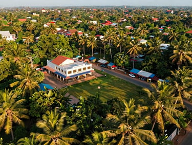 Lush green roadside commercial plot in Kasaragod, wide-angle drone view, bright tropical daylight, clear title.