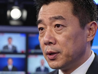 Close-up of a broadcast anchor's face under hard studio lighting, mid-sentence during breaking news segment, monitors visible in background, high contrast, intense and focused expression