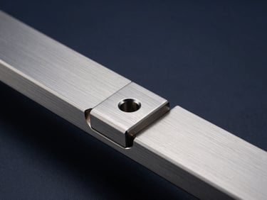 Macro close-up of premium brushed titanium hardware, cool diffused studio light, sharp metallic edges with subtle silver reflections, wide aspect ratio.