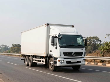 Wide environmental shot of a clean modern transport truck driving on a spacious Indian highway during bright daylight, pristine focus.