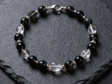 A luxury energy necklace featuring raw clear quartz and dark obsidian beads, arranged symmetrically on a dark slate background.