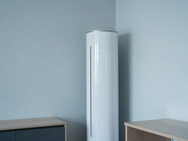 A sleek modern apartment interior with soft cool daylight, a minimalist white air conditioner standing elegantly next to a desk, clean lines, 35mm photography