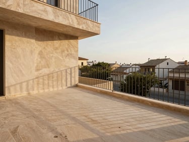 Architectural photograph of a newly built residential terrace in Valencia, high-quality limestone flooring, minimalist metal railings, warm natural afternoon light, editorial 35mm