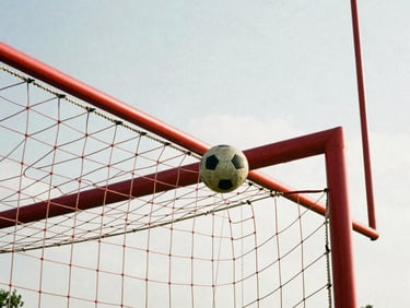 Close-up of a football hitting the back of the net, high-contrast natural daylight, red goalposts, 35mm film grain.