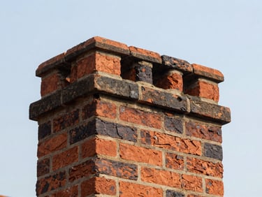 Historic brick chimney top being repaired, showing a new crown and freshly sealed joints, natural daylight, clear sky, focused on the texture of the brick and mortar, 35mm