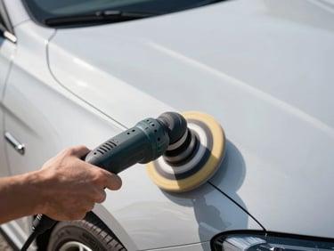 Close-up of a high-end car's fender reflecting bright natural sunlight, a professional dual-action polisher buffing the paint, crisp details.