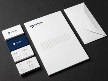 Flat-lay of corporate identity system components — business cards with soft-touch laminate, letterhead, and envelope on dark paper surface under studio strobe, showing substrate texture and edge quality