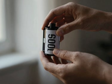 Moody editorial photography, hands gently holding an old cinematic film canister, warm champagne highlights, soft focus.