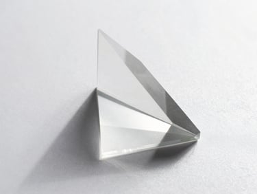 Macro detail of an abstract glass prism refracting clean white daylight on a matte silver surface, sharp geometric shadows, minimalist tech aesthetic