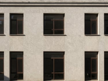 Wide symmetrical architectural crop of a finished exterior facade, natural daylight hitting perfectly flat walls.