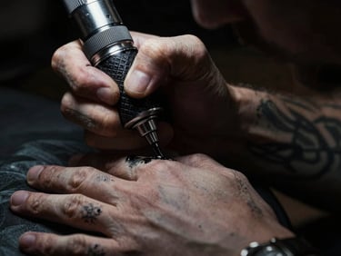 Moody dark-mode photography, close-up of a tattoo artist's hands with black ink stains, working under a focused spotlight