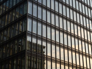 Abstract architectural lines of a modern glass office facade reflecting natural side-lighting, sharp focus