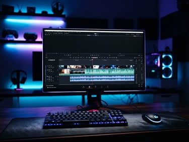 Sleek dark-mode gaming setup with vibrant neon blue and purple ambient backlighting, close-up on a high-fps monitor displaying a video editing timeline, shallow depth of field, 35mm
