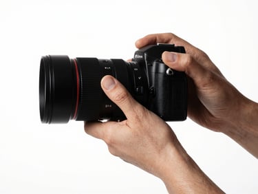 Clean studio portrait of a photographer's hands adjusting a lens on a camera, creative work in progress, high-contrast crisp lighting, 50mm lens