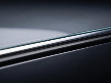 Macro shot of a multi-layer window film edge, showing a clear, thin top layer with a subtle sheen, under crisp studio lighting, technical diagram style.