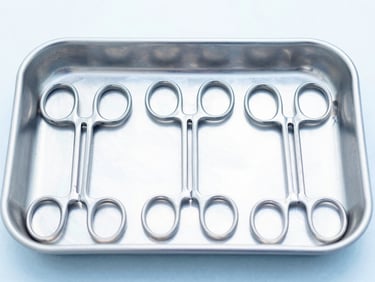 Sharp studio photograph of neatly organized laparoscopic surgical instruments on a sterile metal tray, clean clinical daylight, sharp focus, 50mm