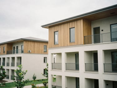 A newly constructed modern community housing building with green spaces, soft overcast daylight, architectural detail.