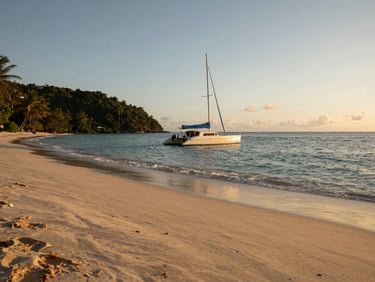 Wide environmental shot of a secluded tropical bay at sunset, a single catamaran resting at anchor near a quiet beach, soft shadows.