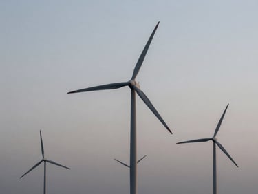 Panoramic view of a modern wind farm at dawn, turbines silhouetted against a cool, desaturated sky, minimalist composition, sharp focus.