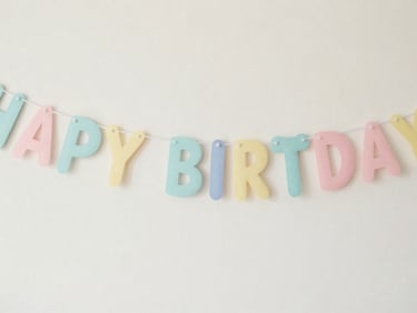 Close-up of a pastel 'Happy Birthday' banner with subtle dog bone accents, soft focus background