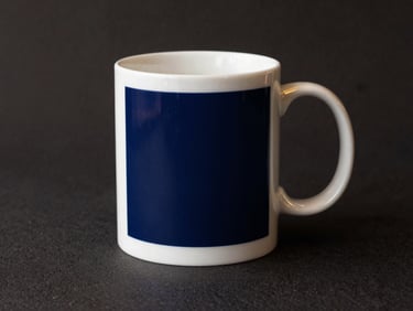Minimalist elegant ceramic mug with crisp custom sublimation print, placed on a textured dark surface, gold accents
