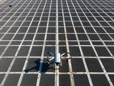 Wide shot of an agricultural grid from above, industrial drone in the foreground, high contrast daylight, technical framing.