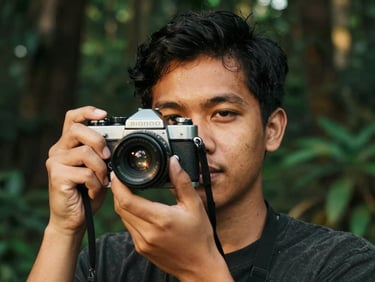Close-up portrait of a young Malay man holding an old film camera, soft environmental lighting, deep forest green tones
