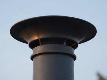 Close-up of a new top-sealing chimney damper being installed, blue sky background, natural light