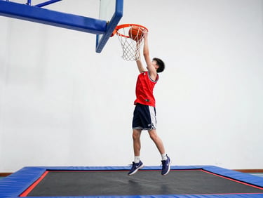 A teenager dunking a basketball on a hoop positioned over a trampoline, dynamic low-angle action shot, crisp details