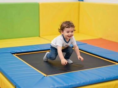 A toddler smiling and playing safely in a soft, brightly colored foam play area with gentle mini-trampolines, bright safe environment