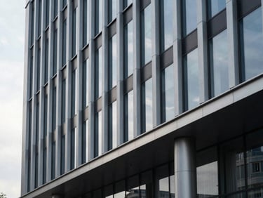 Minimalist architectural detail of a modern corporate building facade in Chișinău, sharp clean lines, steel and glass under cool overcast morning light.