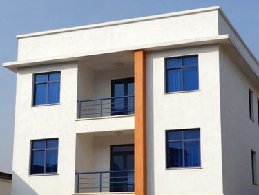 A modern multi-story building completed in Limbe, clean white plaster, architectural details, bright afternoon sun