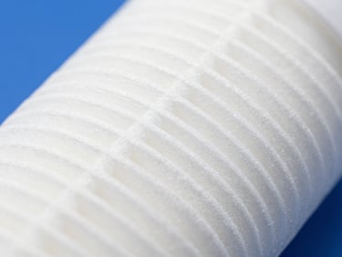 Extreme close-up of a new white sediment filter cartridge, pristine and sterile, under bright high-key natural daylight, crisp focus.