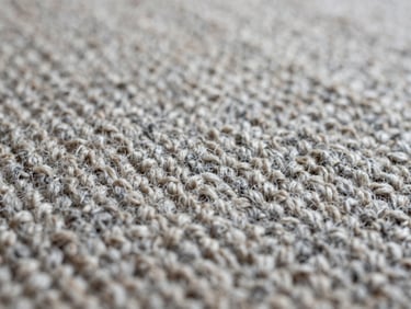 Macro shot of intricate wool carpet pile showing detailed yarn weave and texture