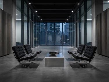 Symmetrical wide-angle shot of a minimalist corporate lounge setup with black leather Bauhaus chairs and brushed steel tables under sharp gallery lighting