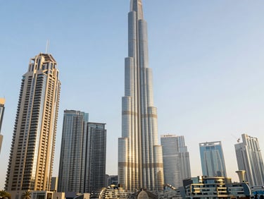 The soaring skyline of Dubai's international financial center, gleaming glass towers under bright golden hour light, architectural focus